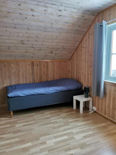 a bedroom with a bed in a room with wooden walls at Blabergan Lodge in Nord-Lenangen