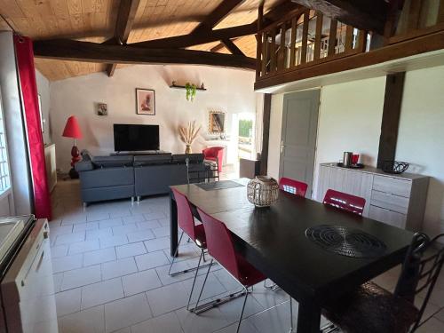 une cuisine avec une table et des chaises dans une pièce dans l'établissement Maison à la campagne avec piscine privée et balnéo, à Sendets