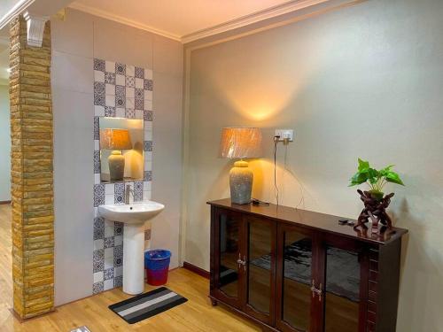 een badkamer met een wastafel en een tafel met een lamp bij Rumah Tok Wan Dee (House 5 Rooms) 2024 in Wakaf Baharu