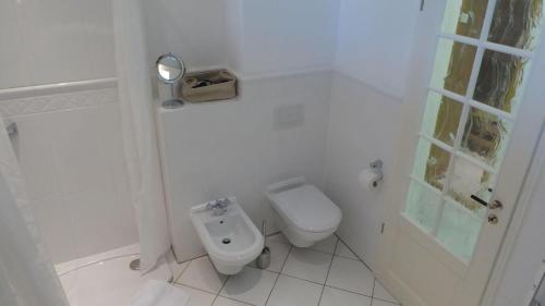 a white bathroom with a toilet and a shower at Gut-Rattelvitz-Parterre-C-hochwertig-Sauna-Kamin-eTankstelle-Spielscheune-15-000qm-Parkland in Gingst