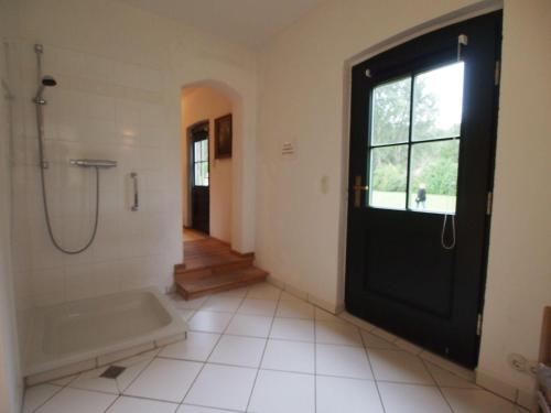 une salle de bain avec douche et porte noire dans l'établissement Gut-Rattelvitz-Galerie-D-hochwertig-Sauna-Kamin-eTankstelle-Spielscheune-15-000qm-Parkland, à Gingst