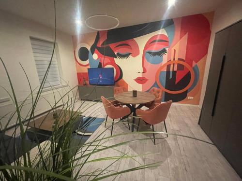 a room with a table and a painting of a woman at HarzFokus - Wellnest - #Netflix#Wlan#Zentrum in Wernigerode