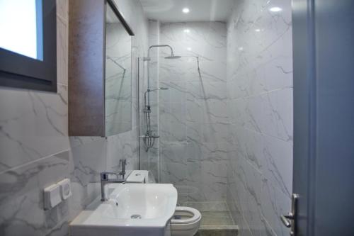 a white bathroom with a sink and a toilet at Lovers Villa Somone in Somone