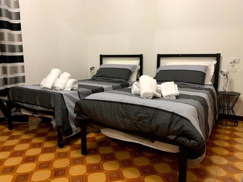 two beds with white pillows on them in a room at CASA CORTE BOTTAZZI in Mirabello
