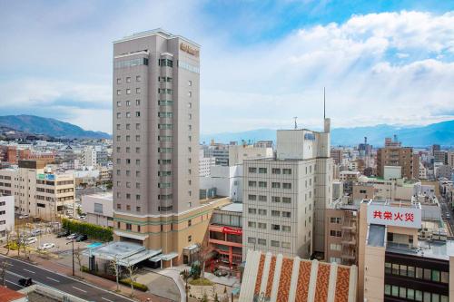 Blick auf eine Stadt mit einem hohen Gebäude in der Unterkunft Kokusai 21 International Hotel in Nagano