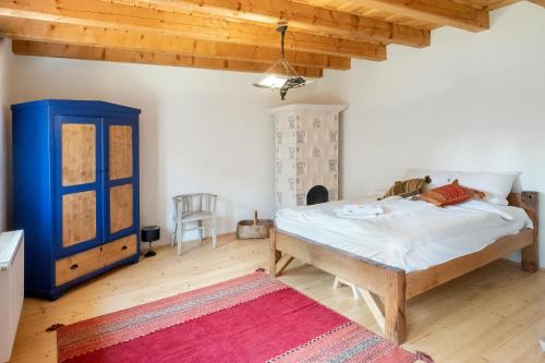 a bedroom with a large bed and a blue cabinet at Ani GuestHouse Richis in Richişu