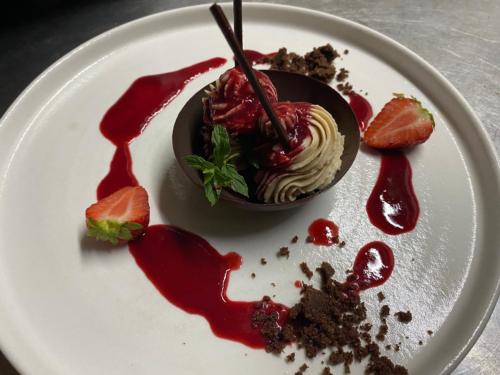 a white plate topped with a dessert with red sauce at Agriturismo Montefabbrello in Magazzini