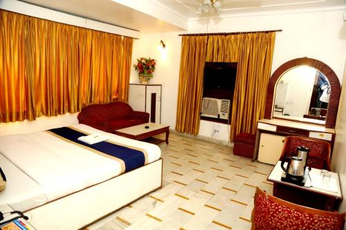 a bedroom with a bed and a chair and a couch at Hotel India international Deluxe in New Delhi