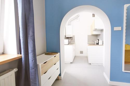 a kitchen with white cabinets and a blue wall at Smart Old Town Apartment in Krakow