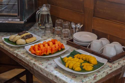 a table with plates of fruits and vegetables on it at Omah Gili Hotel in Gili Air