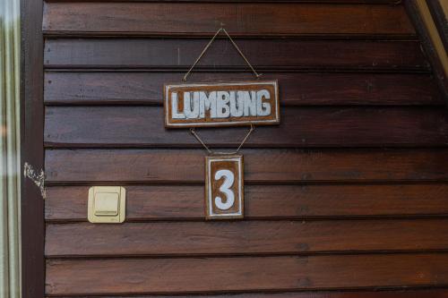 a wooden door with a sign that reads lunchuing at Omah Gili Hotel in Gili Air