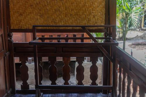 a wooden stairwell with a wooden railing in a building at Omah Gili Hotel in Gili Air