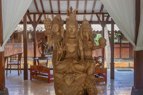 a large wooden statue in the middle of a room at Omah Gili Hotel in Gili Air