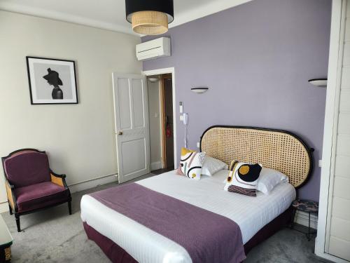 a bedroom with a large bed and a chair at Hôtel Les Nations The Originals Boutique VICHY in Vichy