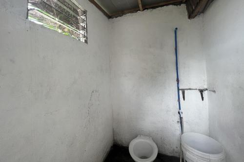 a small bathroom with a toilet and a window at Lover's Point Beach Front Resort in Lian