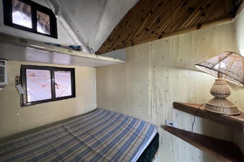 a small room with a bed and a lamp at Lover's Point Beach Front Resort in Lian