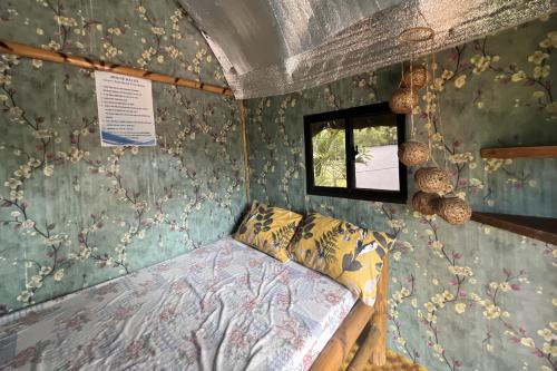 a small bedroom with a bed and a window at Lover's Point Beach Front Resort in Lian