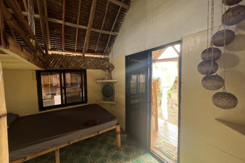 a small room with a bed and a window at Lover's Point Beach Front Resort in Lian