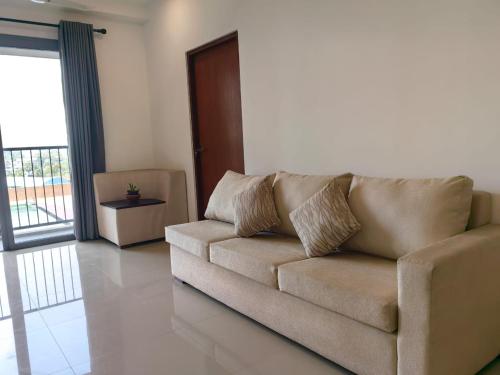 a brown couch in a living room with a door at Stayz by Gentz Residency in Colombo