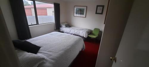 ein kleines Zimmer mit 2 Betten und einem Fenster in der Unterkunft Rakaia Huts Holiday Home in Southbridge