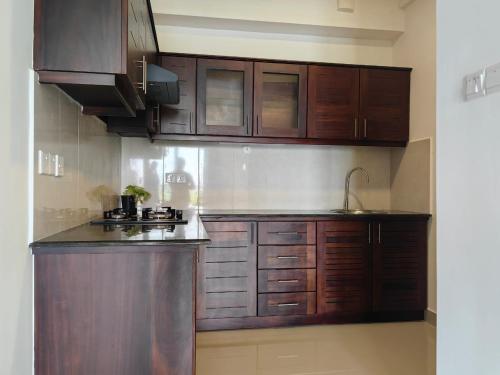 a kitchen with wooden cabinets and a sink at Stayz by Gentz Residency in Colombo