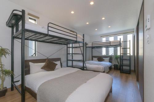 a bedroom with two bunk beds with white sheets at fuu in Fukuoka