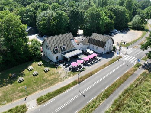 an aerial view of a building with tables and pink umbrellas at Camping de Boskant in Guelle