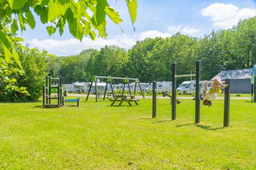 un groupe de balançoires dans un parc dans l'établissement Camping de Boskant, à Guelle