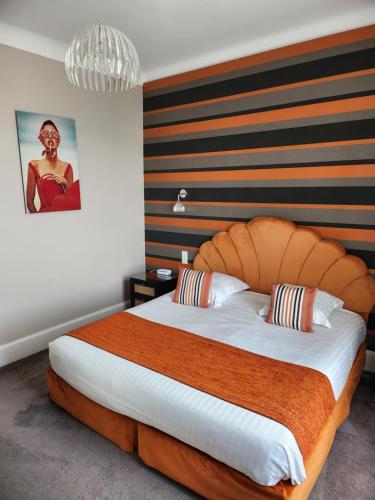 a bedroom with a large bed with a wooden headboard at Hôtel Les Nations The Originals Boutique VICHY in Vichy
