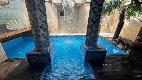 a swimming pool with a fountain in a building at Hotel Casa Rural SPA La Villa in Ávila