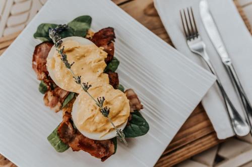 Un plato blanco con comida sobre una mesa. en Godiva Spa & Guesthouse, en Groblersdal