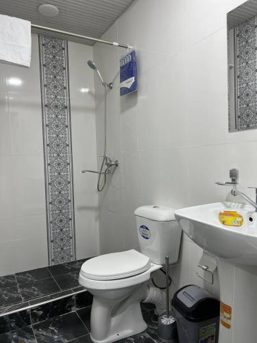 a bathroom with a toilet and a sink at Iyman Hotel in Yakkasaray