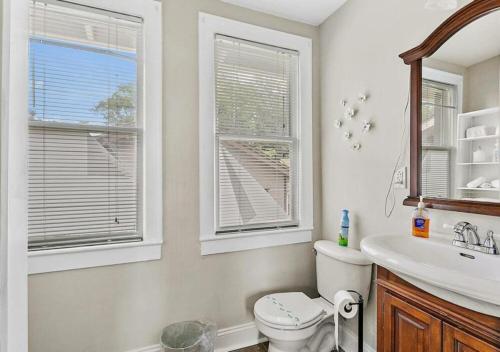 baño con aseo y lavabo y 2 ventanas en Trendy 1 Bedroom Retreat At Jacksonville, en Jacksonville