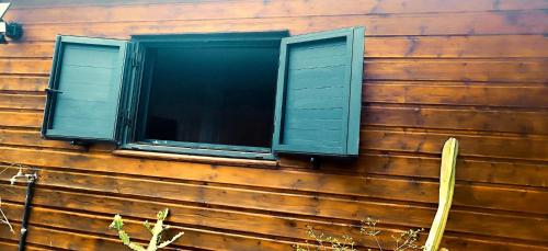 a window on the side of a wooden house at Tiny house Les Cactus - Bungalow St Gilles les hauts in Saint-Paul