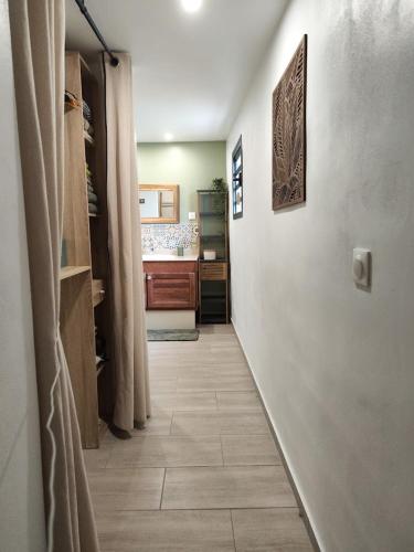 a hallway leading to a kitchen with a hallwayngthngthngthngthngthngthngth at Tiny house Les Cactus - Bungalow St Gilles les hauts in Saint-Paul