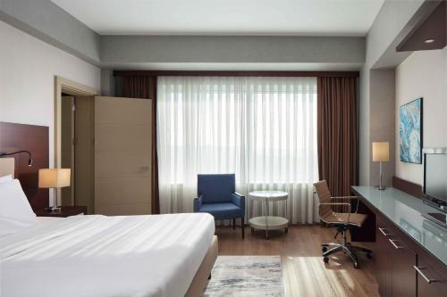 a hotel room with a bed and a chair and a table at Delta Hotels Istanbul West in Istanbul