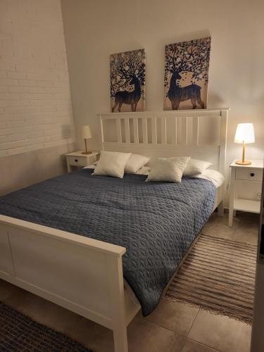 a bed in a bedroom with two pictures on the wall at Apartament Prestiż in Sobótka