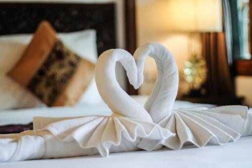 dos cisnes blancos sentados sobre una cama en Hugga Pai, en Pai