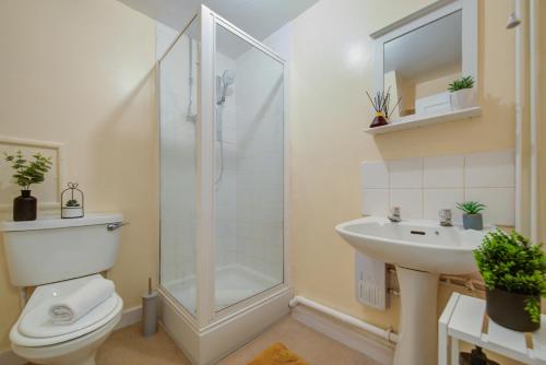 een badkamer met een douche, een toilet en een wastafel bij 1Bed - Contractor-Friendly Apartment - High Street Views in Stamford