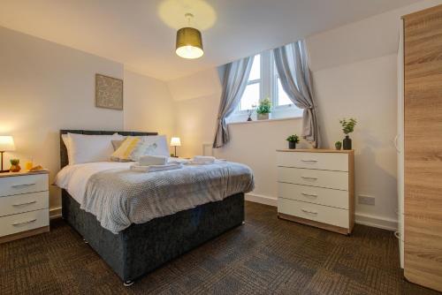 een slaapkamer met een bed, 2 drempels en een raam bij 1Bed - Contractor-Friendly Apartment - High Street Views in Stamford