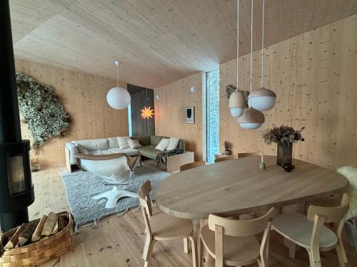 un salon avec une table et des chaises en bois dans l'établissement Villa Jäkälä - An architectural wooden villa by the lake, à Rokua