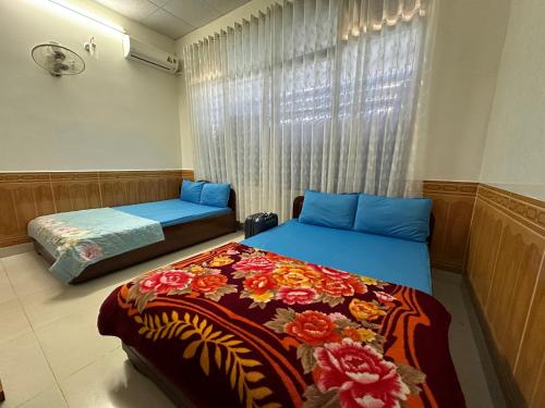 a bedroom with two beds and a window at MoTel HỒ XUÂN in Pleiku