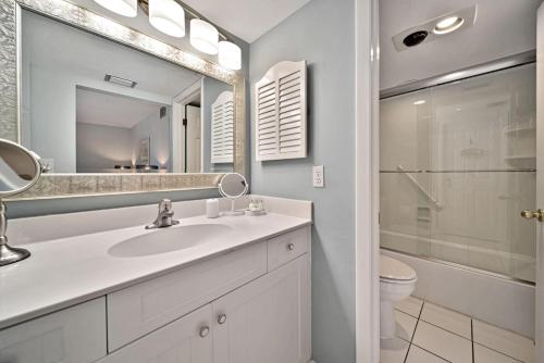 a bathroom with a sink and a toilet and a mirror at Compass Pointe #201 in Sanibel