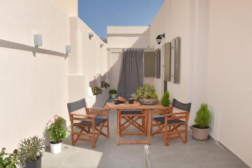 a patio with a wooden table and chairs at Ledio's house in Ermoupoli