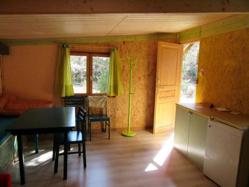 a kitchen with a table and a dining room at sous les arbres in La Palud-sur-Verdon
