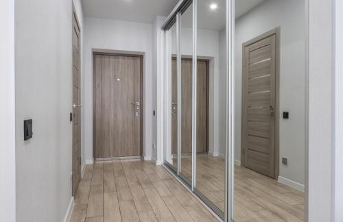 a hallway with two mirrors and a hallway with doors at Люкс на Бориспільській ЖК Олімпік Парк, генератор на будинку in Kyiv