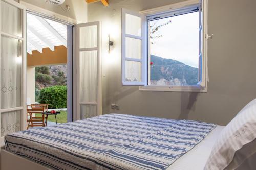 a bedroom with a bed and an open window at Villa Pelagos in Asos