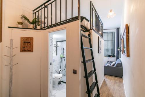 uma pequena casa de banho com uma cama alta numa pequena casa em MBA - Splendide Appart - Patay 1 - Proche Bercy em Paris
