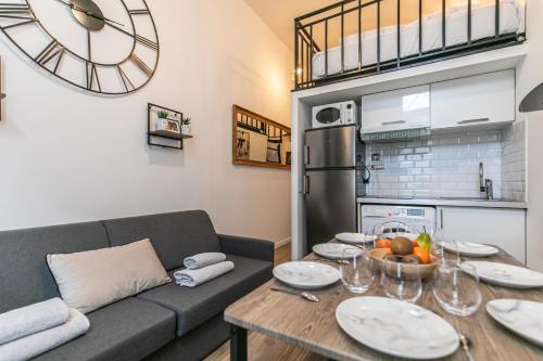 - un salon avec un canapé et une table avec des assiettes dans l'établissement MBA - Splendide Appart - Patay 1 - Proche Bercy, à Paris