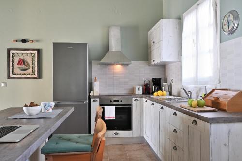 een keuken met witte kasten en een fornuis met oven bij Villa Pelagos in Asos